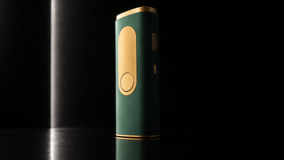A slim rectangular IPL Laser in dark emerald green with gold metallic accents, standing upright on a reflective black surface against a dark background.